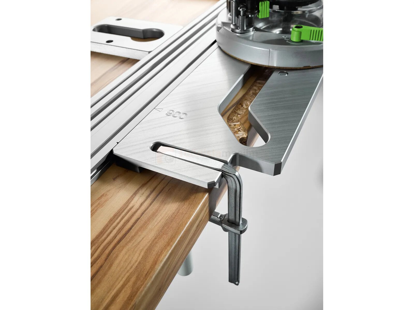 Pildil on Festool töölaua šabloon APS 900/3, mis on kinnitatud töölaua külge ja millega on näha freesimistöö tegemist.