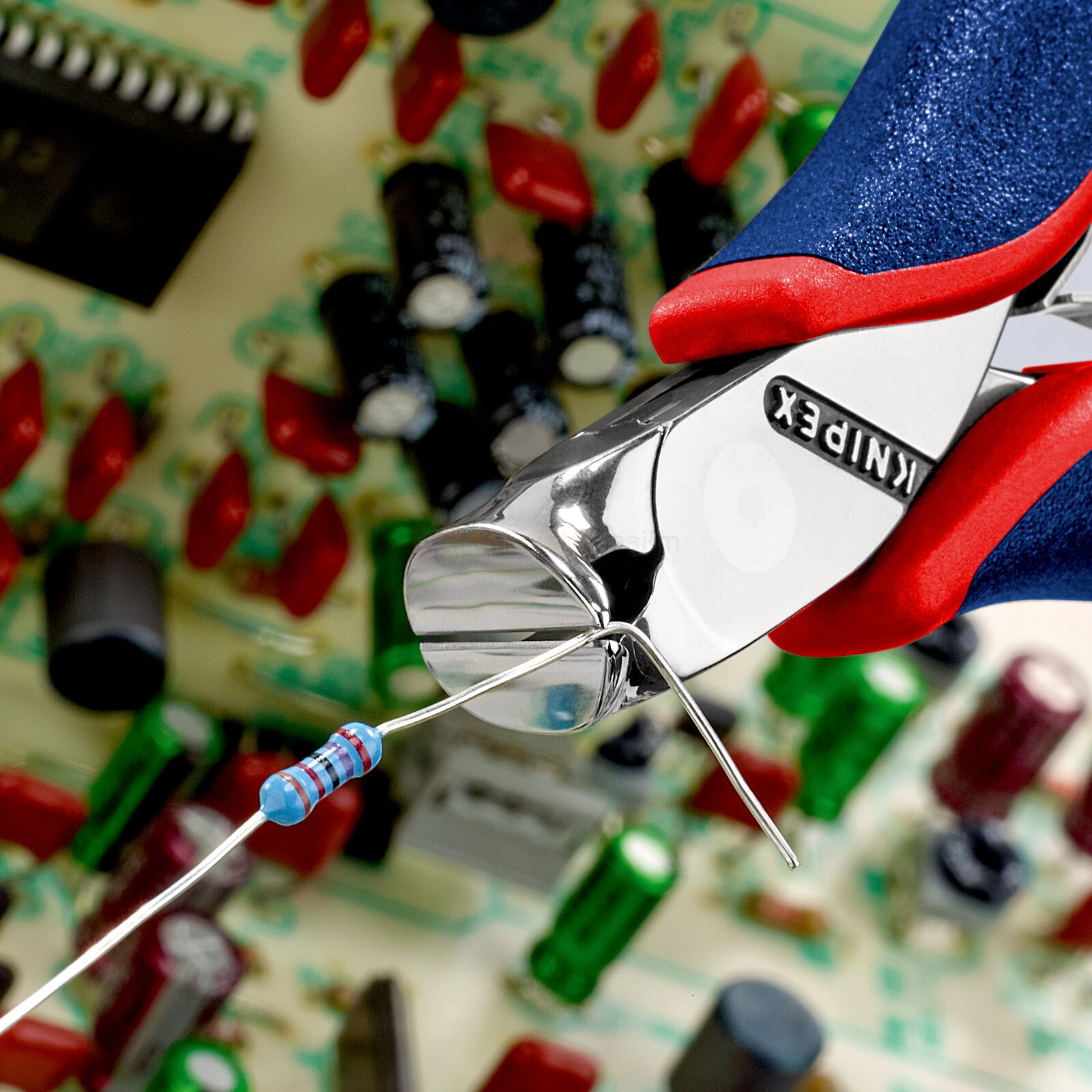 Pildil on näha, kuidas Knipex elektroonika lõiketangid 120 mm lõikavad elektroonilise komponendi jalga.