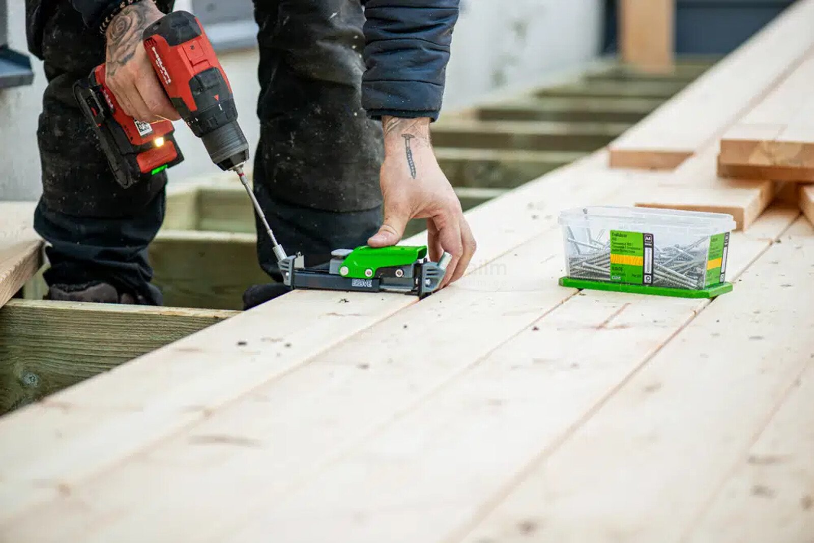 Pildil on ehitaja, kes kasutab Essve otsakut HDS-tööriistale TX15 x 100 mm V3, et kinnitada puitlaudu.