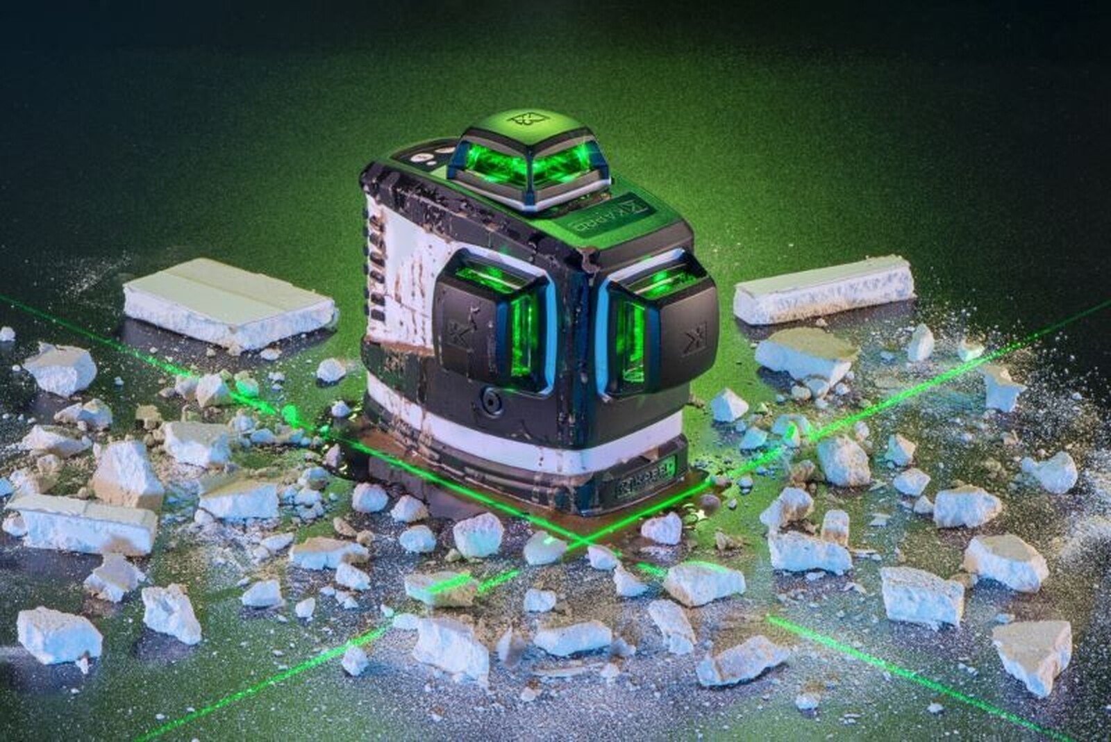 Pildil on Kapro 883HG PROLASER 3D ristlaser, mis projitseerib rohelisi laserkiiri, olles ümbritsetud valgete tükkidega.