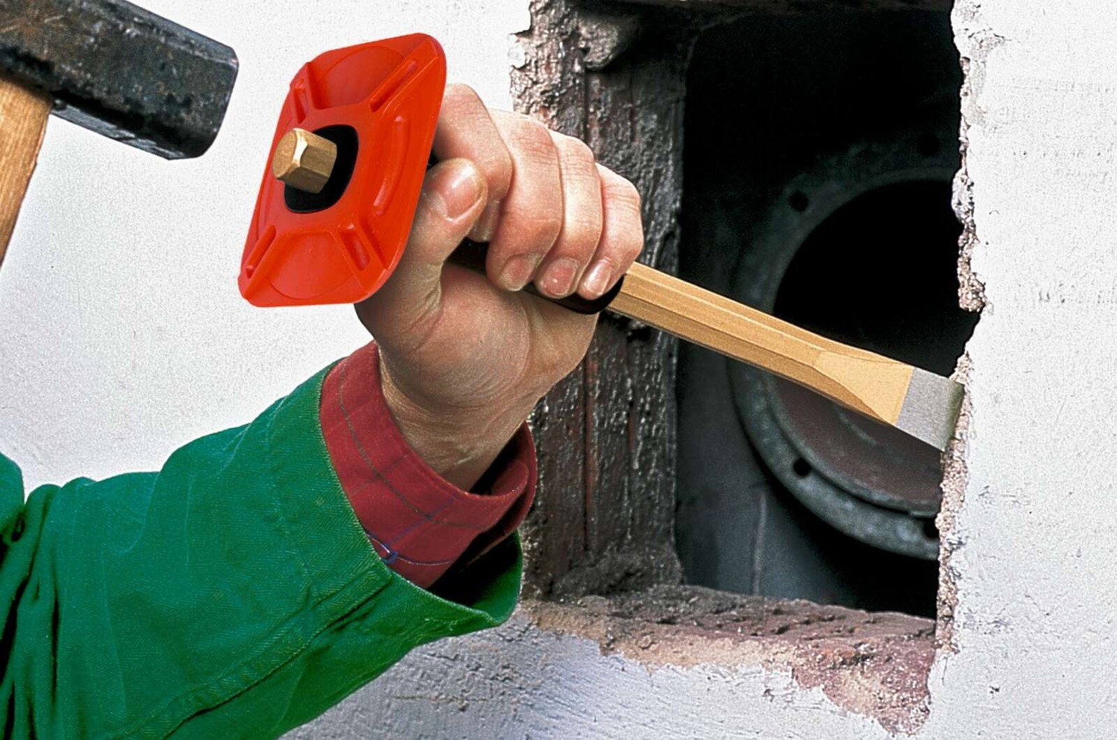 Pildil on näha, kuidas inimene kasutab Rennsteig müürsepameislit 26 x 350 mm, käekaitsega, et lõhkuda seina.