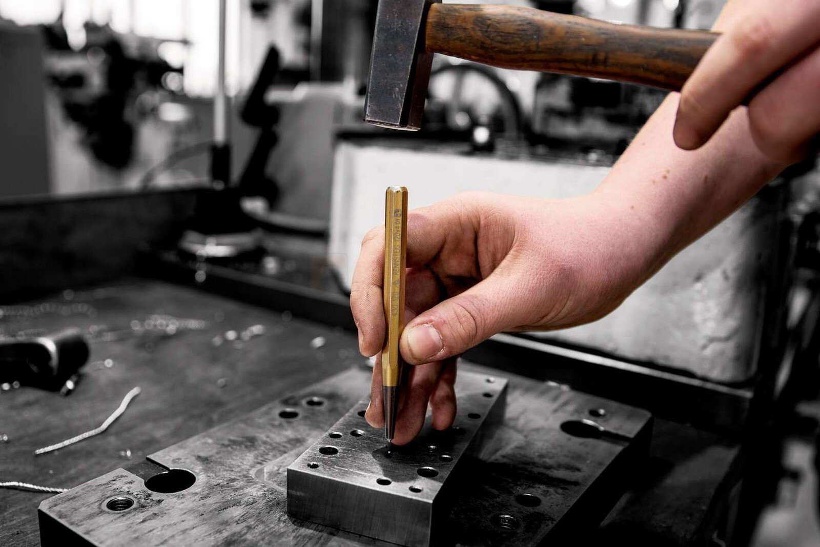 Pildil on näha, kuidas käsitööline kasutab Rennsteig kärni, et lüüa seda haamriga metallplaadi külge.