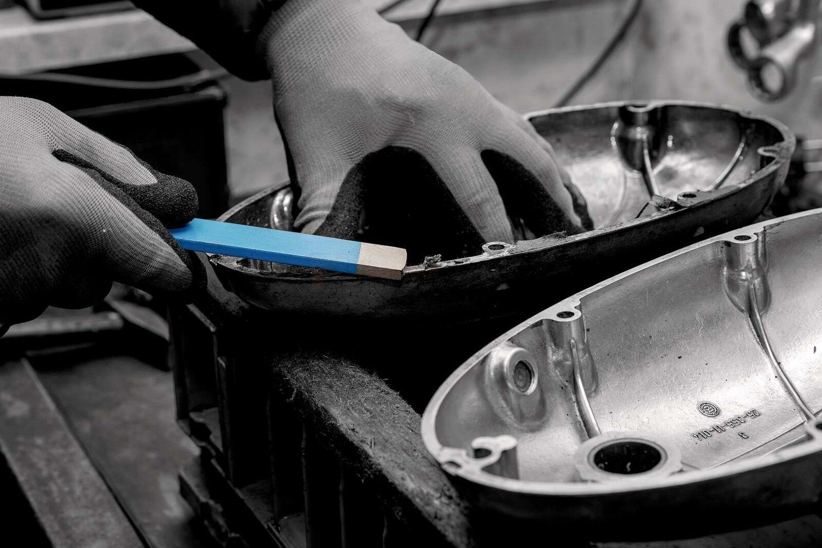 Pildil on näha, kuidas inimene kasutab Rennsteig lamekraabitsat 5 x 20 x 320 mm mootoriosade puhastamiseks.