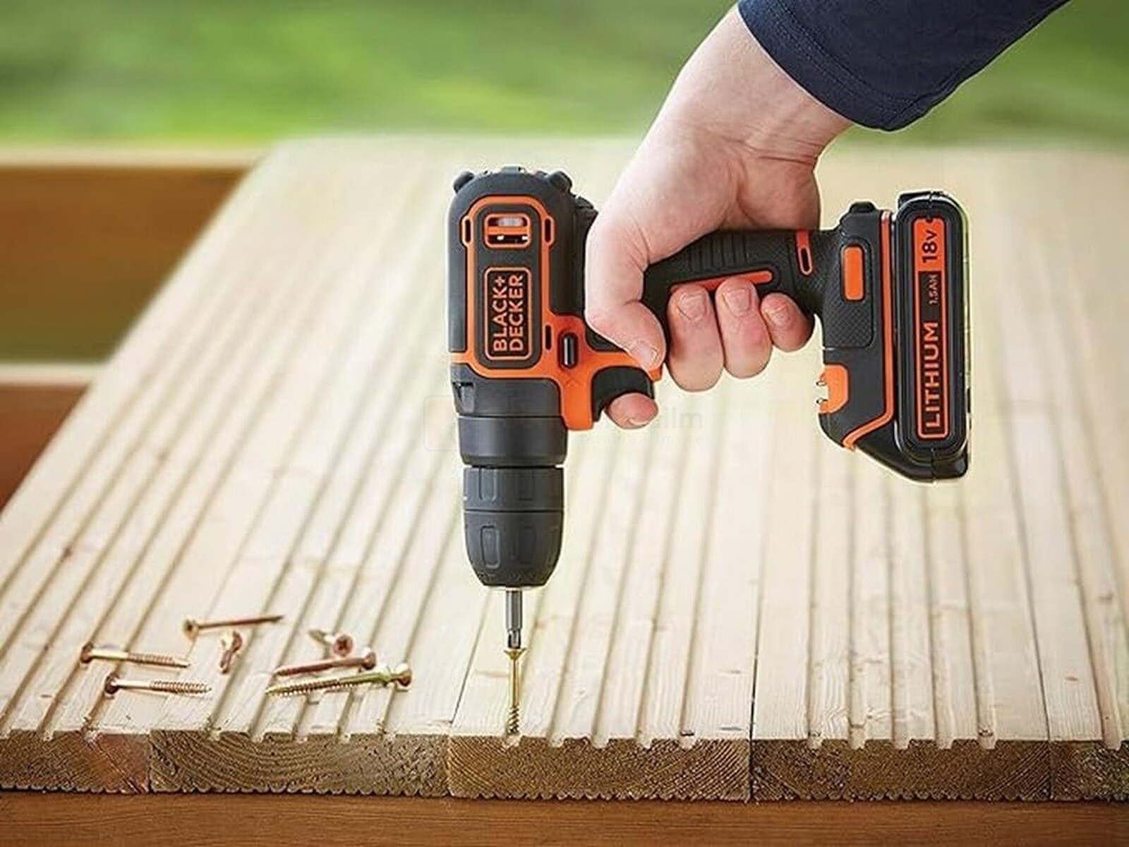 Pildil on näha, kuidas inimene kasutab BLACK+DECKER akutrelli BDCDC18B (2 x 1,5 Ah) puidu sisse kruvide keeramiseks.