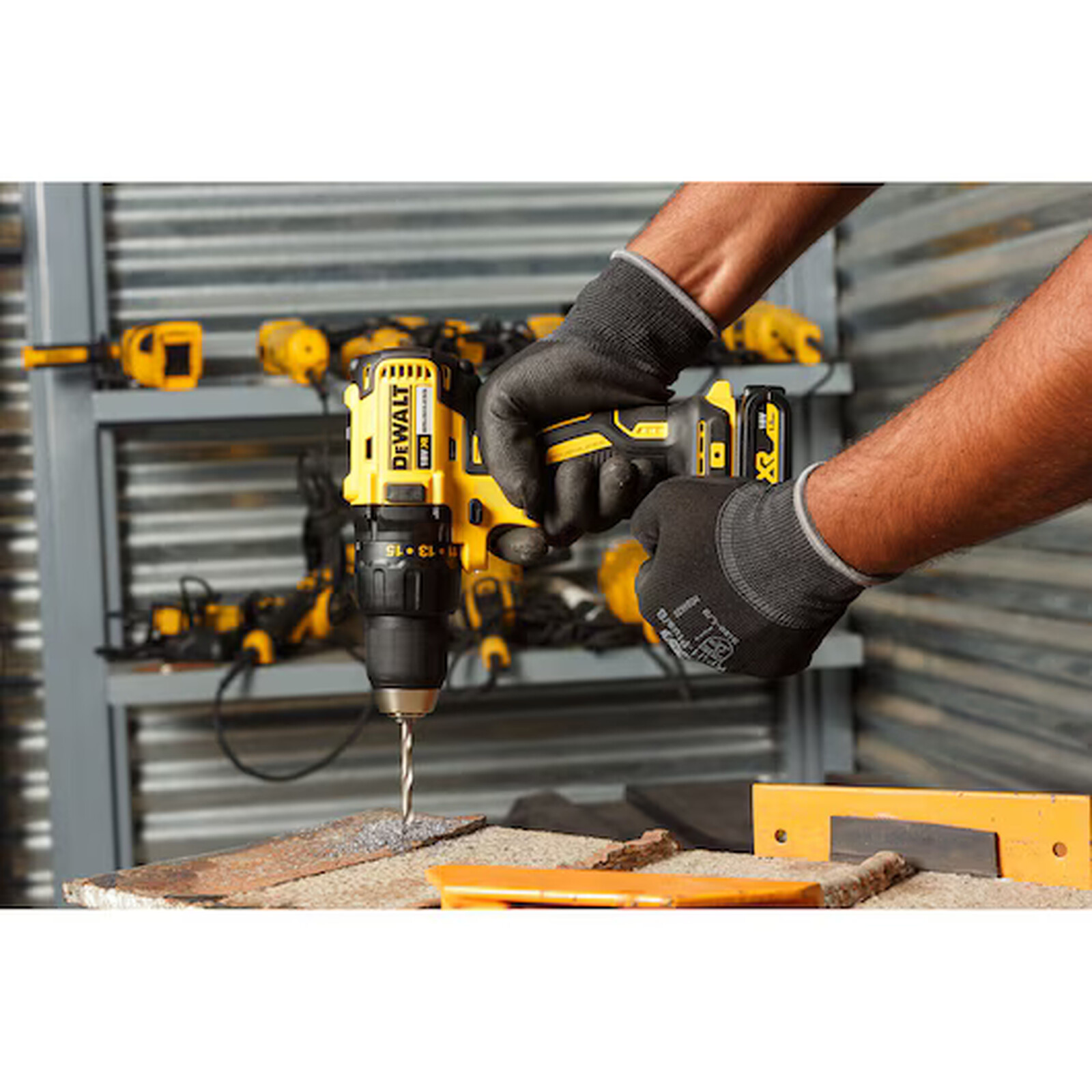 Pildil on näha, kuidas inimene kasutab DeWalt akutrelli DCD777S2T, et puurida auku materjali, samal ajal kui ta kannab...