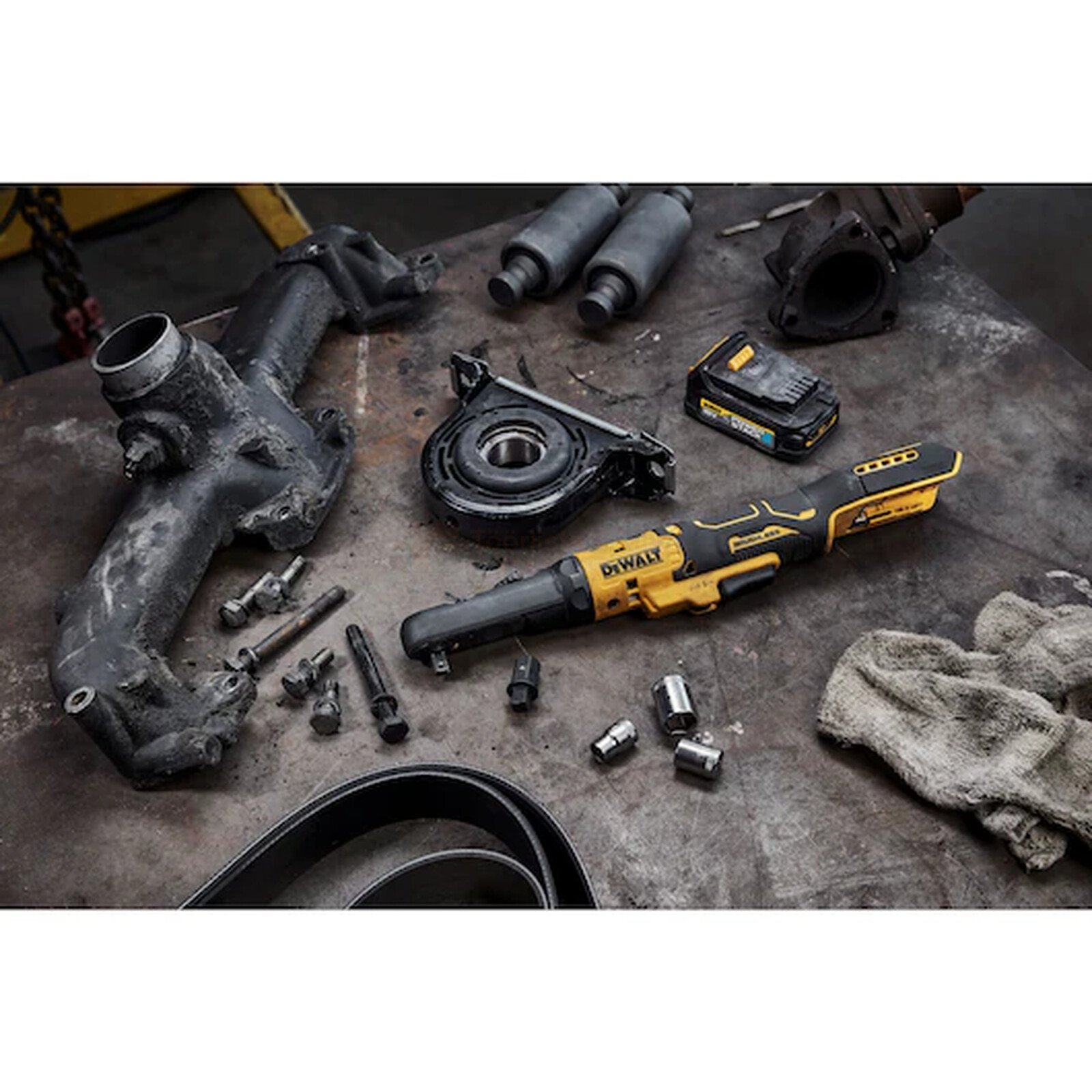 Pildil on DeWalt akunarre DCF510N koos erinevate autovaruosade ja tööriistadega, mis on paigutatud töölauale.