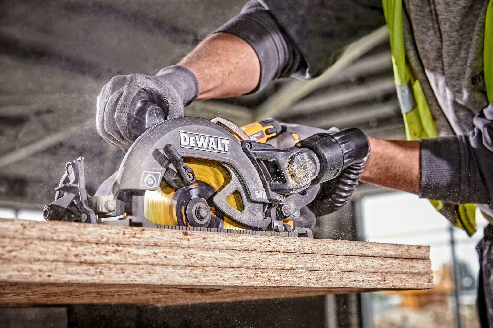 Pildil on näha, kuidas mees lõikab puidutahvlit DeWalt Flexvolt DCS577N akuketassaega, mis on ilma aku ja laadijata.