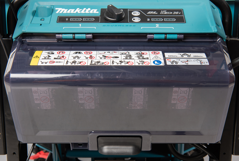 Pildil on detailne vaade Makita akutoitega aiakäru DCU603Z esi- ja pealepaneelile, kus on näha aku paigaldamise koht...