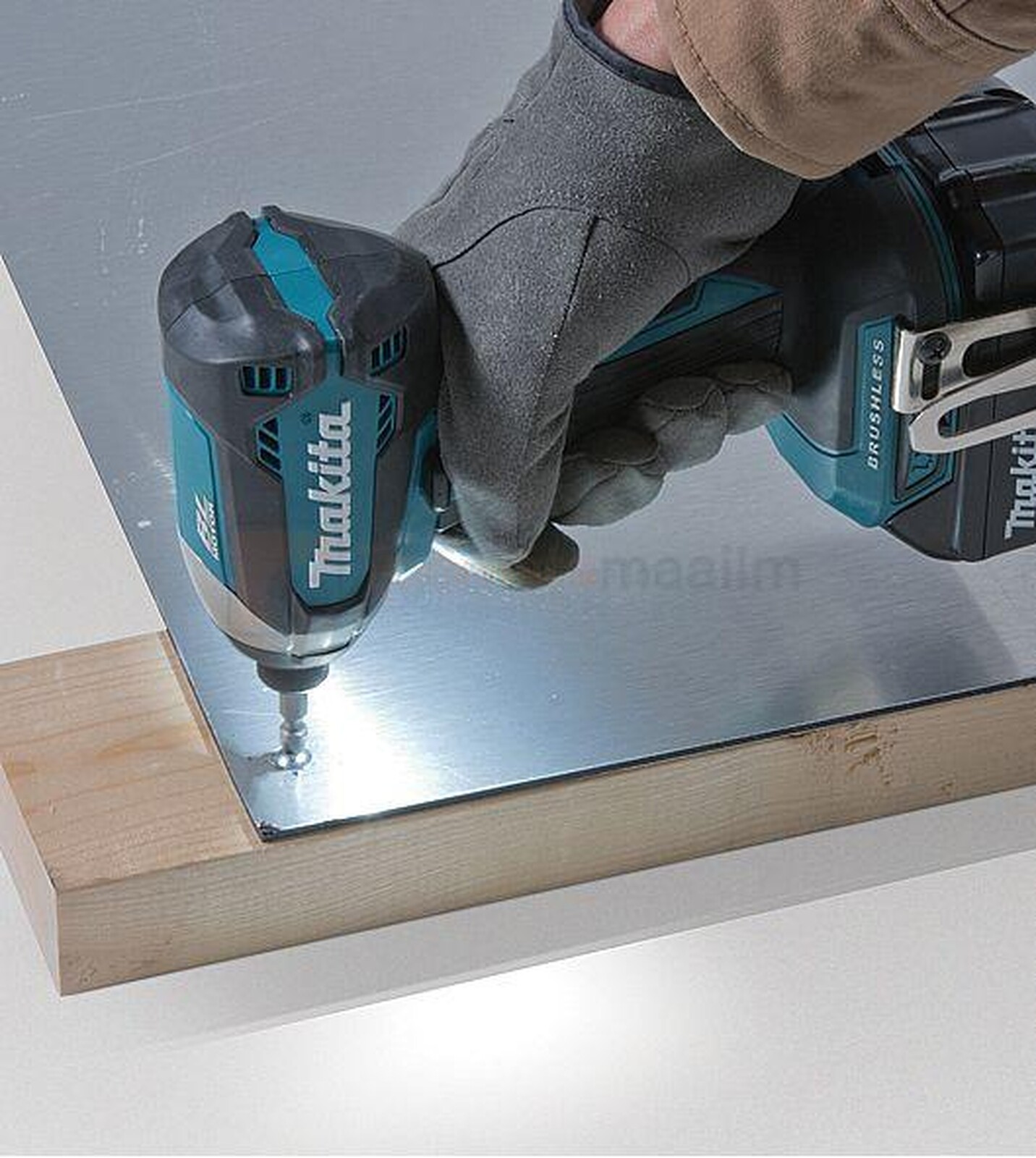 Pildil on näha, kuidas inimene kasutab Makita DLX2535TJ combokiti kuuluvat löökmutrikeerajat, et kinnitada kruvi...