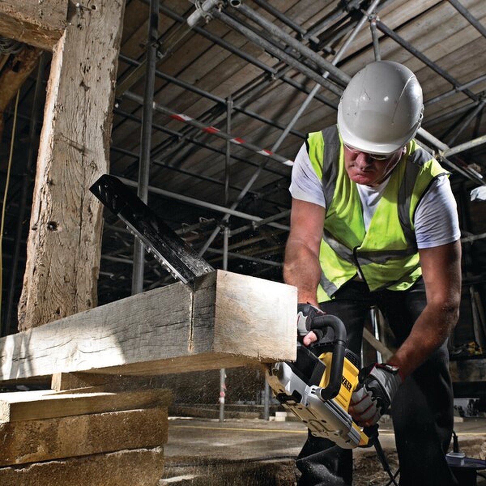 Pildil on ehitaja, kes kasutab DeWalt alligaatorsaega puidu lõikamiseks.