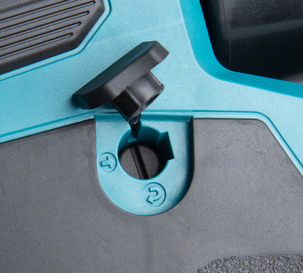 Pildil on detail Makita akukaablipressi DTC302ZK korpusest, nähtavad on ava koos sulguriga ja suunamisnooltega.