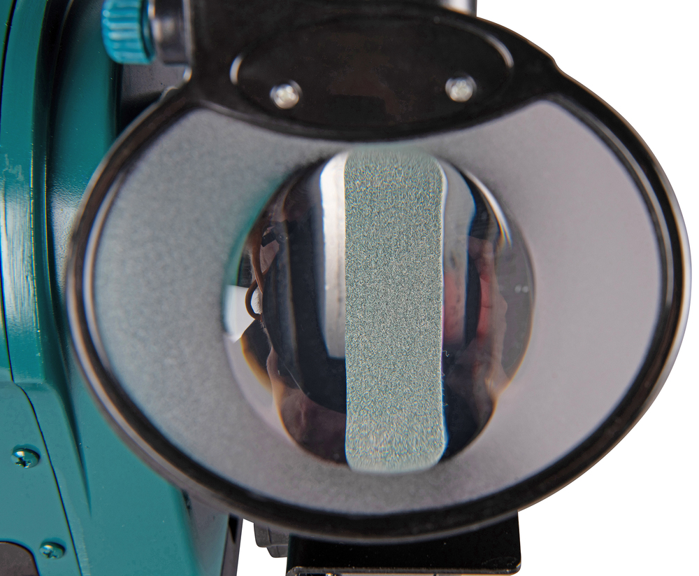 Pildil on detailne vaade Makita elektrikäia GB801 pealt, kus läbi suurendusklaasi on näha lihvkivi.