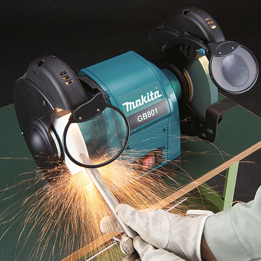 Pildil on Makita GB801 elektrikäi, millega keegi lihvib metallist detaili, tekitades sädemeid.