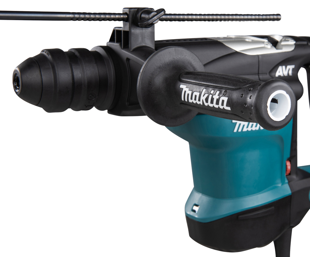 Pildil on detailne vaade Makita puurvasarile HR3210FCT, nähtavad on seadme ots, külje käepide ja detailid korpusel.