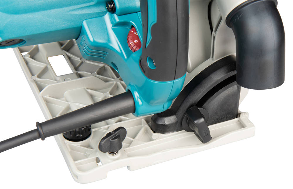 Pildil on detailne vaade Makita SP6000J ketassaest, kus on näha sae korpus, reguleerimisketas, alus ja tolmueemaldusotsak.