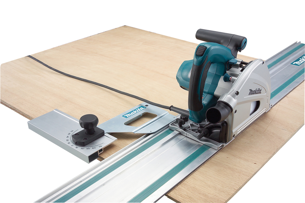 Pildil on Makita ketassaag SP6000J, mis on paigutatud puidust lauale.