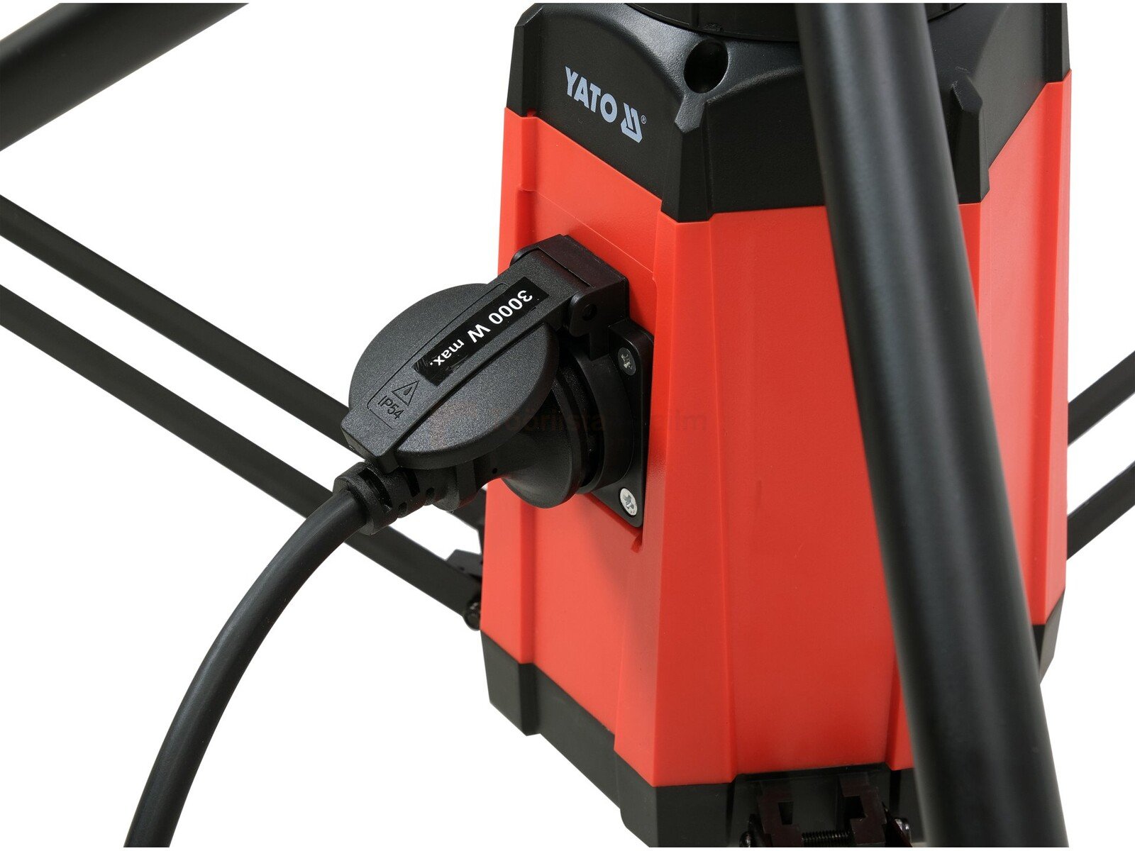 Pildil on näha YATO töövalgusti, millel on punane korpus ja must kaabel, mis on ühendatud pistikupessa.