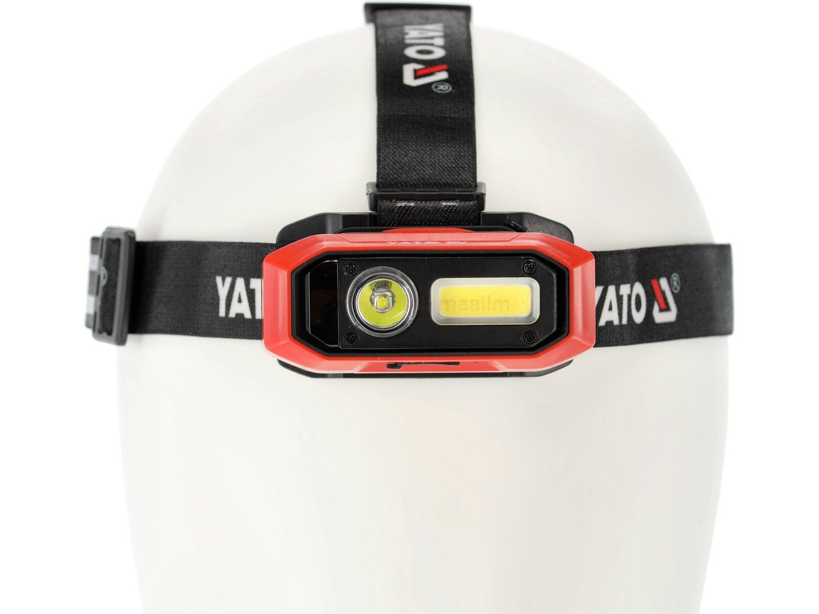 Pildil on valgel mannekeenil Yato pealamp, millel on punane raam, kaks valgusallikat ja must rihm.
