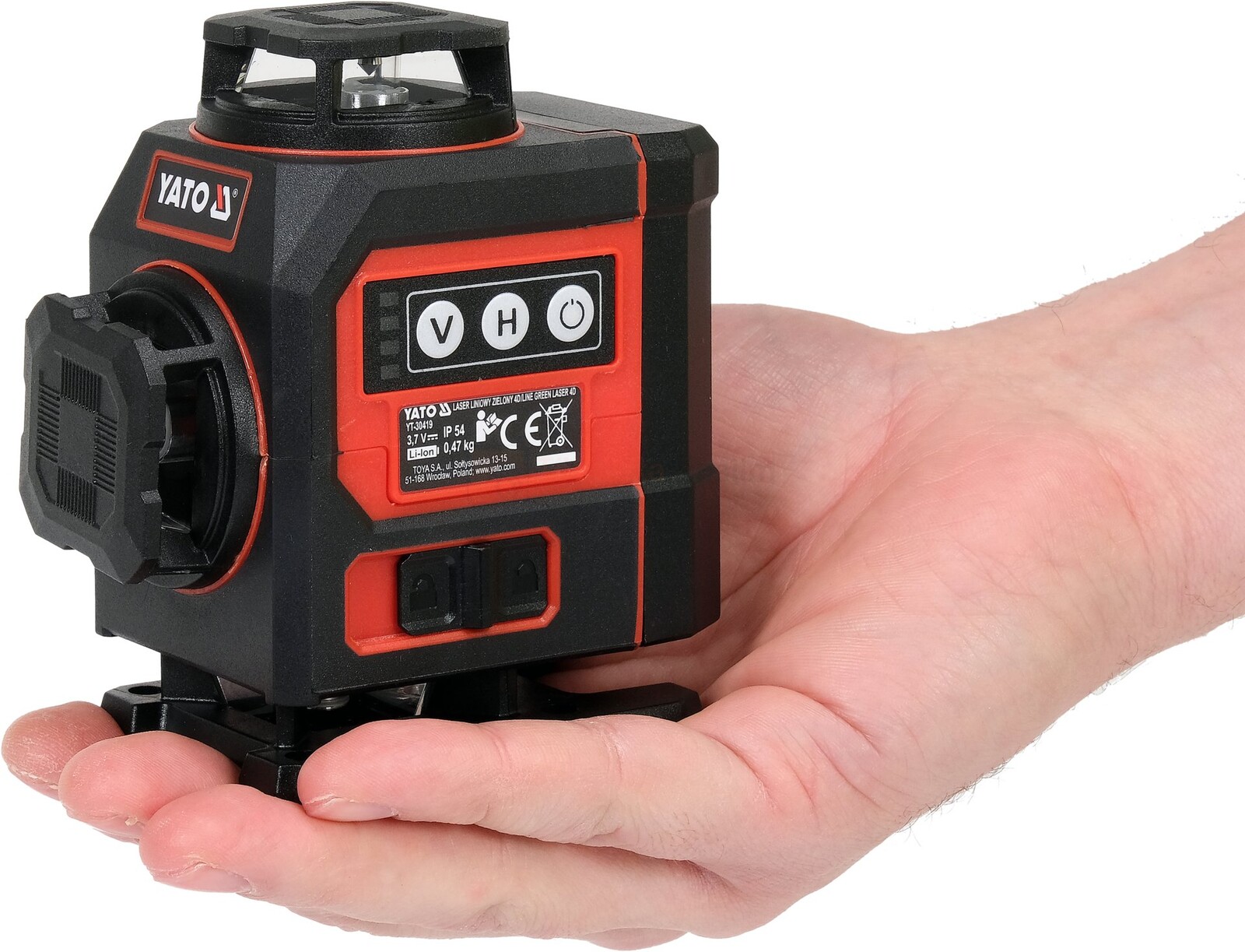Pildil on inimese peopesal YATO 4D roheline joonlaser koos tarvikutega, mis on punase ja musta korpusega.