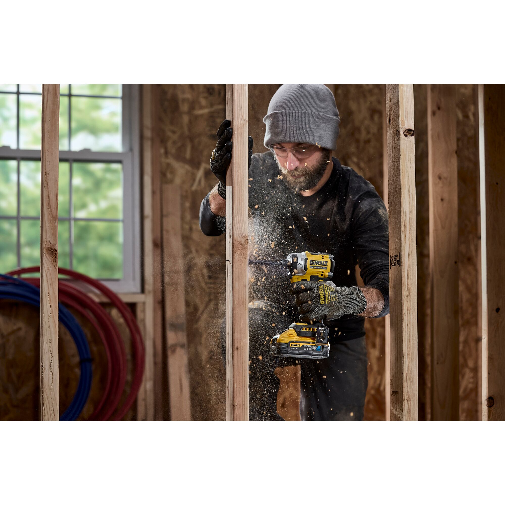 Pildil on mees, kes kasutab DeWalt akulöökkruvikeerajat DCF860N, ilma aku ja laadijata, et puurida puitraami sisse, ning...