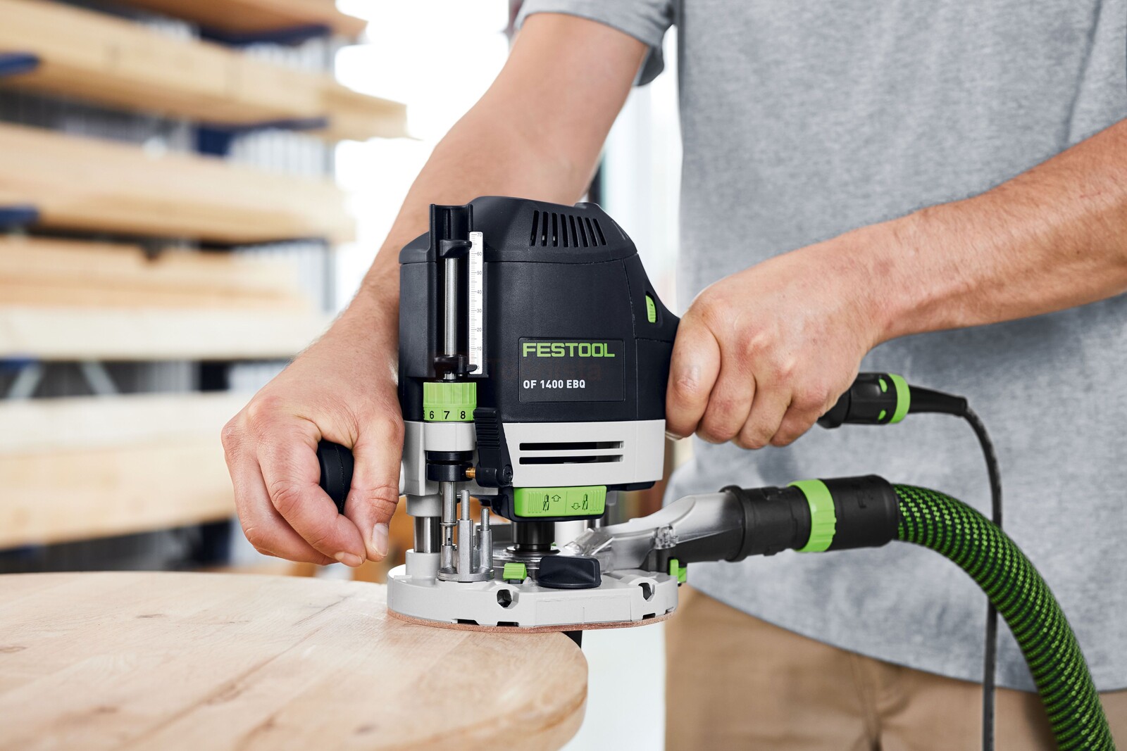 Pildil on näha meest kasutamas Festool ülafreesi OF 1400 EBQ-Plus, et töödeldavat puitosa freesida.