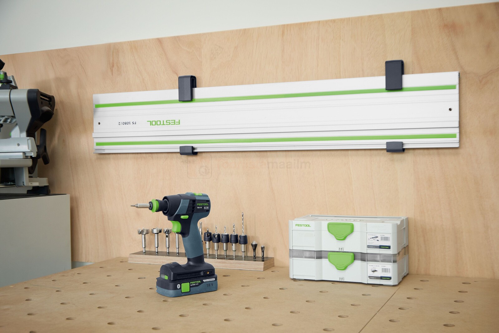 Pildil on Festool juhtsiini hoidik HA-FS/2, mis on paigaldatud puidust seinale ja mille küljes on näha kinnitusi, lisaks...