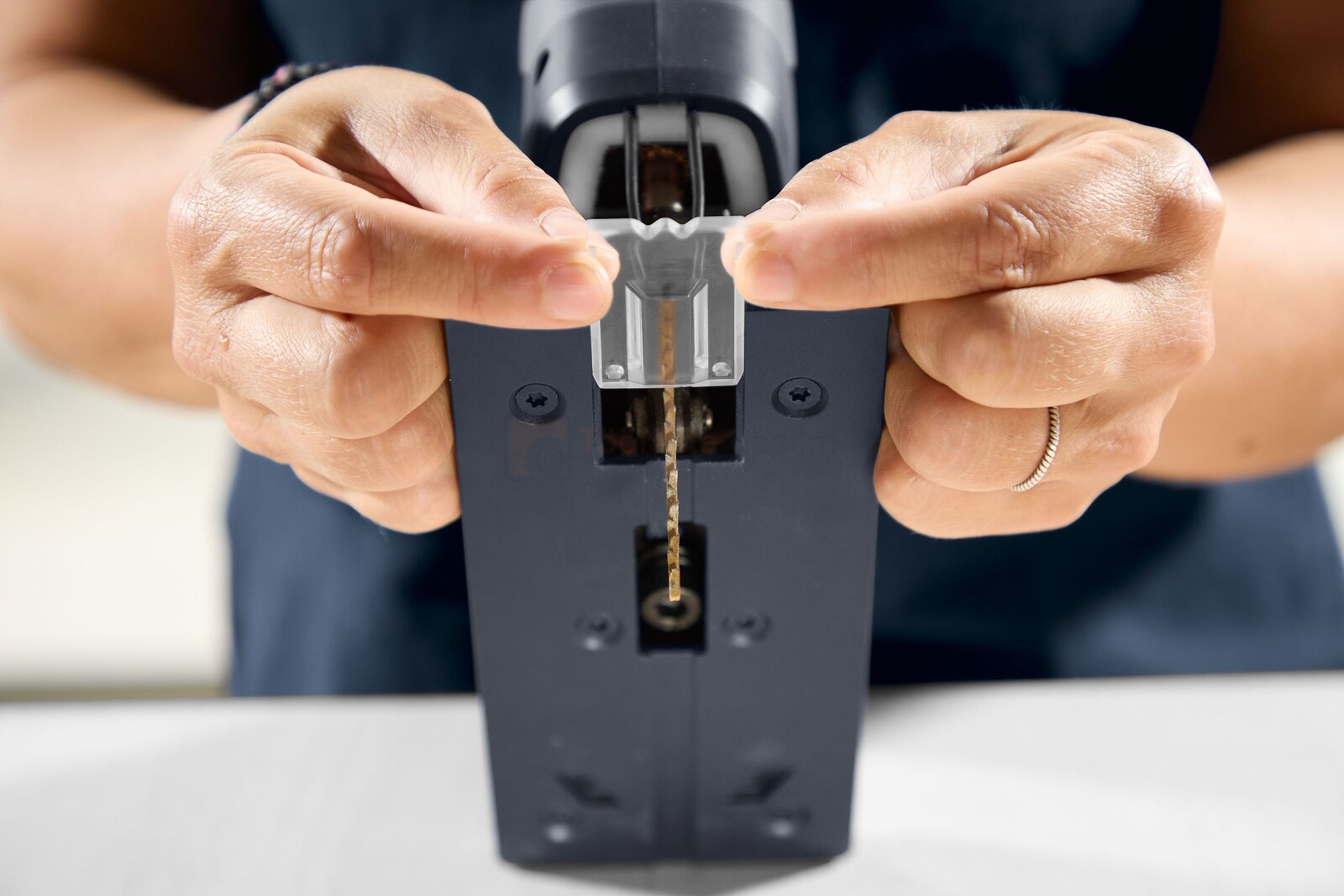 Pildil on näha, kuidas inimene paigaldab Festool akutikksaagi PSC-E 18 EB-Basic saelehte.