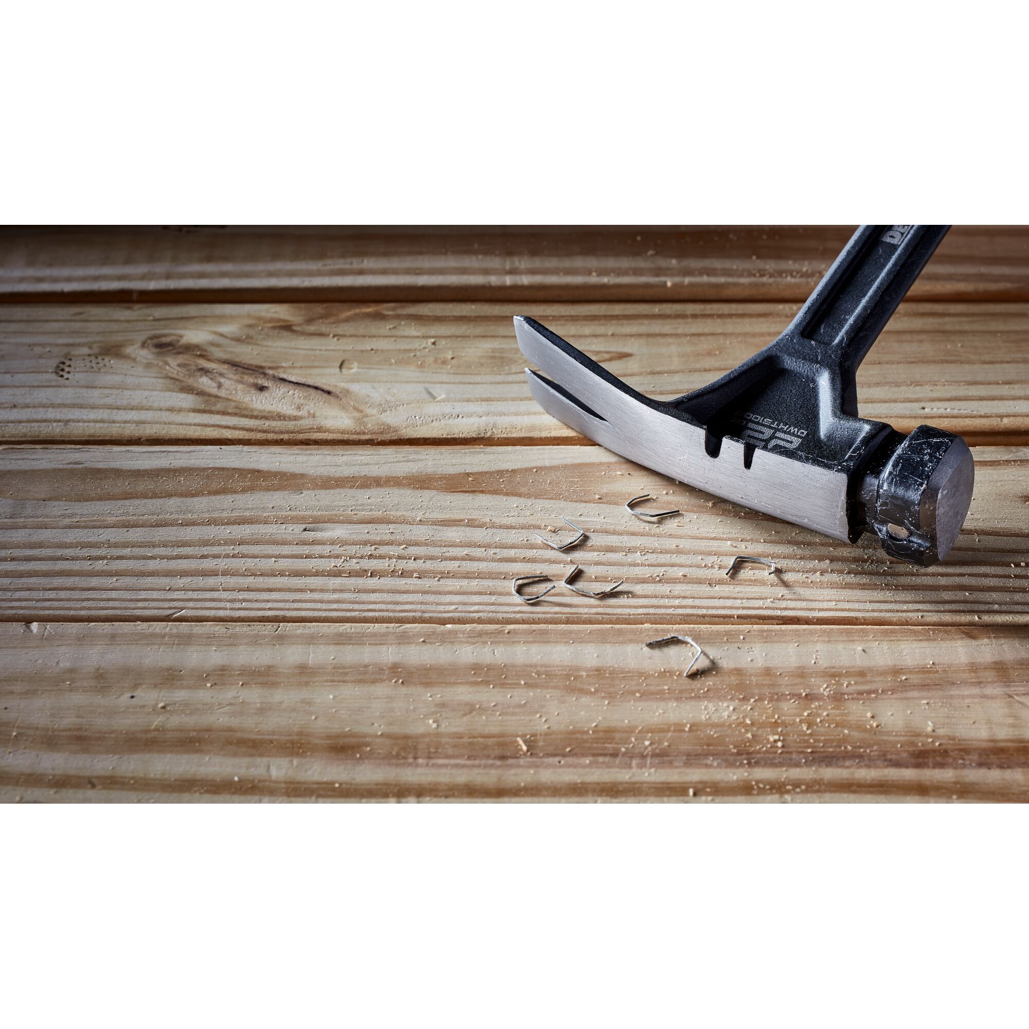 Pildil on DeWalt sõrgvasar 624 g, sileda peaga, mis on asetatud puitpinnale ning millega on tõmmatud välja klambreid.