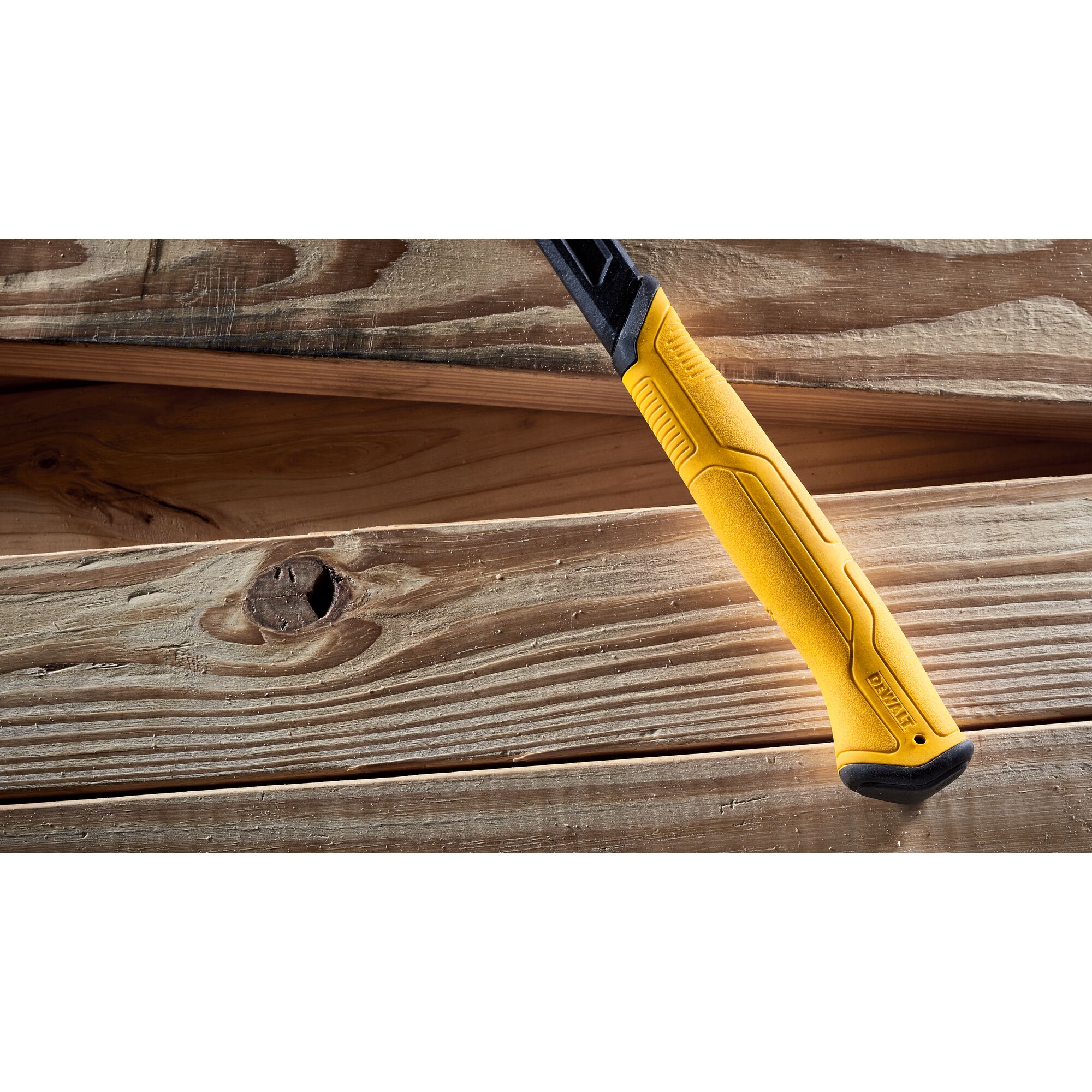 Pildil on DeWalt lammutusvasara kollane käepide, mis on asetatud puitpindadele.