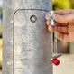 Pildil on käsi, mis hoiab KNIPEX standardvõtit hoonete tehniliste seadmete jaoks, millega avatakse metallist posti uks.