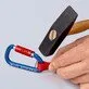 Pildil on näha, kuidas haamriga lüüakse Knipex karabiini, mille külge on kinnitatud punane rihm, demonstreerides selle...