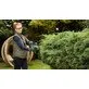 Pildil on naine, kes kasutab Bosch akutoitega hekilõikurit EasyHedgeCut 18V-44-11 heki pügamiseks.