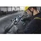Pildil on töölise poolt kasutatav Bosch akulöökmutrikeeraja GDS 18V-780, mis keerab mutreid suure metalltoru külge...