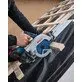 Pildil on näha, kuidas inimene kasutab Bosch ristlõike juhtsiini FSN 740 X koos akuga ketassaega puidu lõikamiseks.
