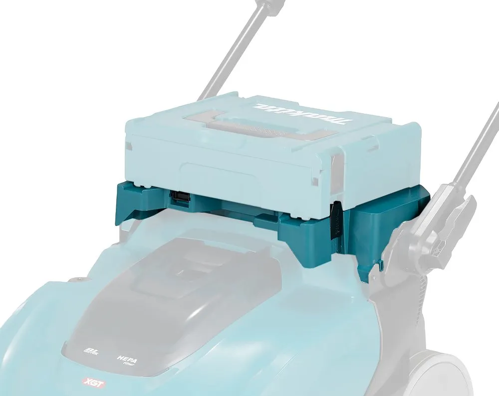 Pildil on Makita multifunktsionaalne adapter VS001G, mis on paigaldatud muruniidukile ja mille peal on näha aku.
