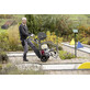 Pildil näeb meesterahvast, kes transpordib Kärcher HD 17/15 G kõrgsurvepesurit minigolfiväljakul.