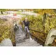 Pildil on mees, kes kasutab Kärcheri kõrgsurvepesurit HD 9/23 G treppide puhastamiseks.