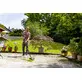 Pildil on mees, kes kasutab Kärcher survepesurit K 4 Comfort Premium Home, et puhastada betoonpinda õues.
