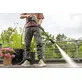 Pildil on mees, kes kasutab Kärcher K 5 Comfort Premium Connect survepesurit, et puhastada terrassi, nähes seadme võimsat...