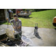 Pildil on mees, kes kasutab Kärcher kõrgsurvepesurit HD 5/13 EX Plus Classic, et pesta lõikurit, mis asub haagises.