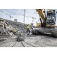 Kärcheri kõrgsurvepesur HD 6/14-4 M Cage on pildil kasutuses ehitusplatsil, kus seda kasutatakse suure ekskavaatori...