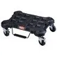 Pildil on must Milwaukee PACKOUT™ Trolley ratastega alus, millel on peal erinevad kinnituskohad ja millel on neli ratast...