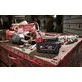 Pildil on Milwaukee M18 B5-CR - 5,0 Ah aku, mis on asetatud koos teiste tööriistadega töölauale.