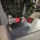 Pildil on mees, kes kasutab Milwaukee akuplekilõikurit M18 FNB35-502X, et lõigata metallplekki.