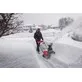 Pildil on mees, kes kasutab Milwaukee akutoitel lumepuhurit M18 F2SSBL-122, et puhastada lund lumetormi ajal.