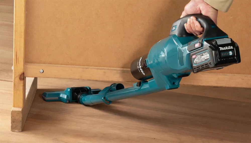 Pildil on Makita aku varstolmuimeja CL003GD203, mida hoitakse käes kontoriruumis.