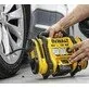Pildil on mees, kes kasutab DeWalt akutoitel kompressorit auto rehvi täispumpamiseks.