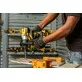 Pildil on näha käed hoidmas DeWalt akulööktrelli DCD996P2, millega trellitakse puurimislauda.