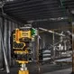 Pildil on DeWalt ristlaser, mis paistab ehitusplatsil tööks kasutatuna, näidates rohelist laserkiirt.