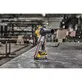 Pildil on DeWalt akulintlihvija DCM200E2T, mis seisab metallpinnal tööstuslikus keskkonnas.